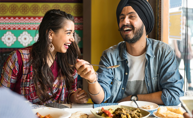 Indian couple smiling while eating