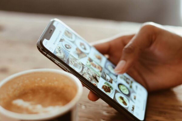 hand holding a phone scrolling on social media